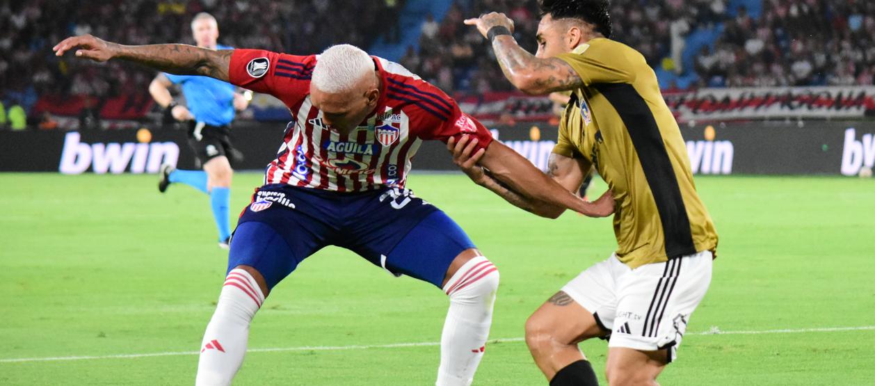 Jermein Peña en un duelo con Marcos Bolados, durante el partido contra Colo Colo.