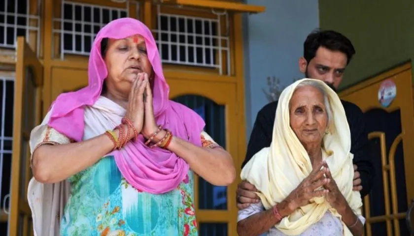 La mujer (i) y la madre de dos de los acusados de violar y asesinar a una niña de ocho años rezan antes del veredicto final, este lunes en Kathua (India). 