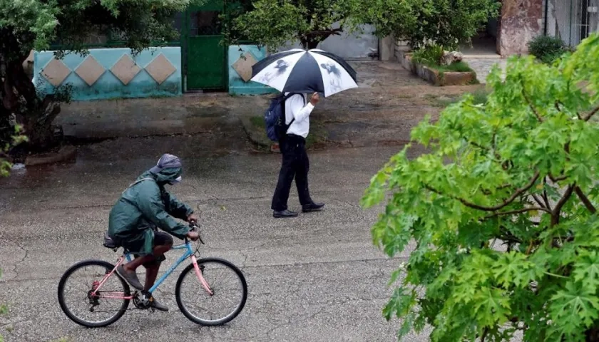 Dos personas se protegen de la lluvia hoy, en La Habana (Cuba).