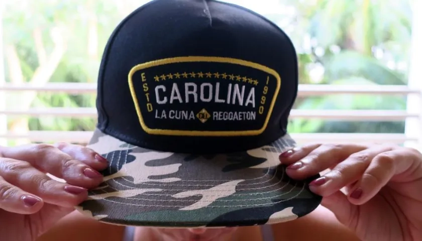 Una mujer muestra hoy una gorra con el nombre de "Carolina", municipio considerado como la cuna del reguetón, en San Juan (Puerto Rico).