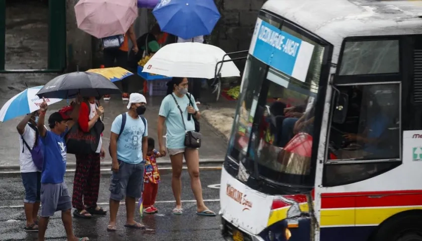 Ciudadanos de protegen de las lluvias con paraguas.