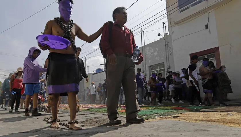 Devotos participan en la procesión de los engrillados este Viernes Santo, durante las celebraciones de Semana Santa, en el municipio de Atlixco, en Puebla.