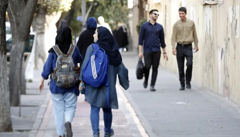 Jóvenes iraníes con pañuelo en la cabeza en una calle de Teherán en octubre de 2022