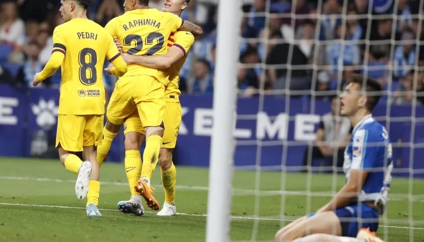 Los jugadores del FC Barcelona Pedri (i), Raphinha y Lewandowski celebran el tercer gol del equipo, ante la mirada del defensa del Espanyol César Montes