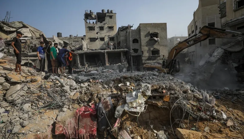 Palestinos buscan entre los escombros de la casa de la familia Al Faseih destruida tras un ataque aéreo.