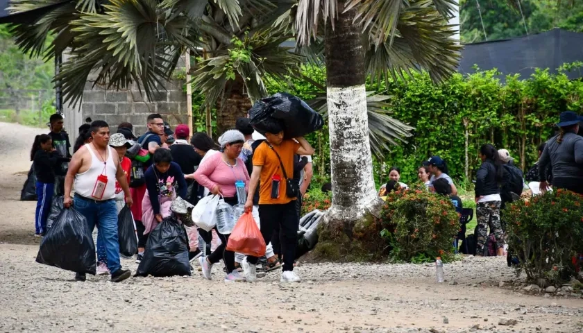 Migrantes cargando sus pertenencias en la entrada a la selva del Darién.