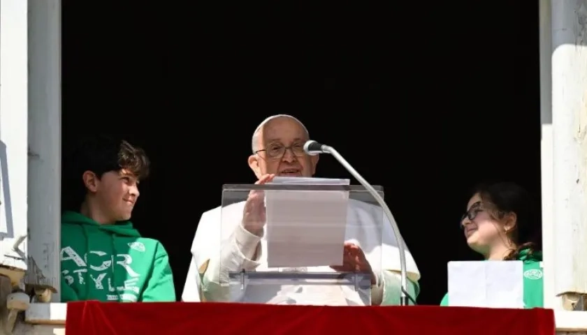 El Papa Francisco asomado desde el balcón junto a dos jóvenes de Acción Católica