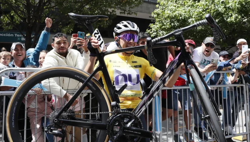 Rodrigo Contreras carga su bicicleta tras coronarse campeón del Tour Colombia. 
