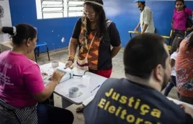  La indígena y pedagoga de la etnia Baré Ana Claudia Martins Tomas (2i), de 40 años, hace su identificación biométrica antes de votar en la comunidad rural de "Nossa Senhora do Livramento", en el Río Negro.