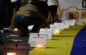 Velas encendidas, con cartelitos con los nombres de los líderes asesinados.