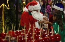 Hombre vestido como Papá Noel compartiendo con los niños.