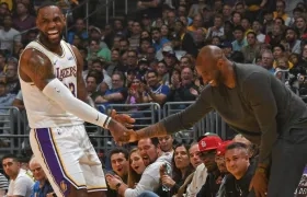 LeBron James le da la mano a Kobe Bryant durante un partido de los Lakers. 