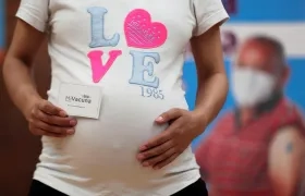 Una mujer embarazada muestra su carnet de vacunación tras recibir la vacuna de Pfizer contra la Covid-19