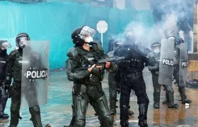 Miembros del Escuadrón Móvil Antidisturbios (Esmad) se enfrentan a manifestantes durante una jornada de protestas en Bogotá.