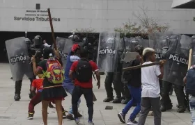 Indígenas se enfrentan durante una protesta con el Esmad de la Policía en Medellín.