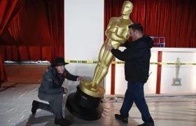 Dos hombres encargados de la logística mueven la figura icónica de los Premios Óscar 2023.
