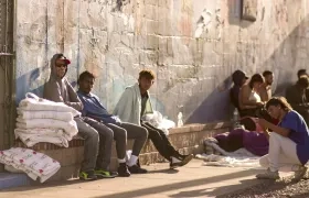 Varios migrantes esperan el sábado en una calle en El Paso, Texas 