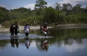 Personas migrantes cruzan el río Tuquesa, en Darién (Panamá), en una fotografía de archivo. 