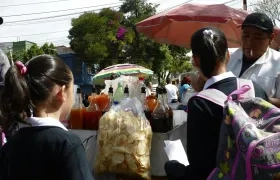 Unas niñas estudiantes compran frituras afuera de un colegio en Ciudad de México
