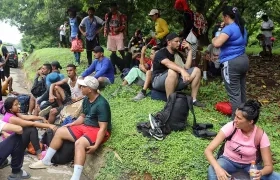 Migrantes descansan a un costado de la vía, en el municipio de Huixtla en Chiapas (México).