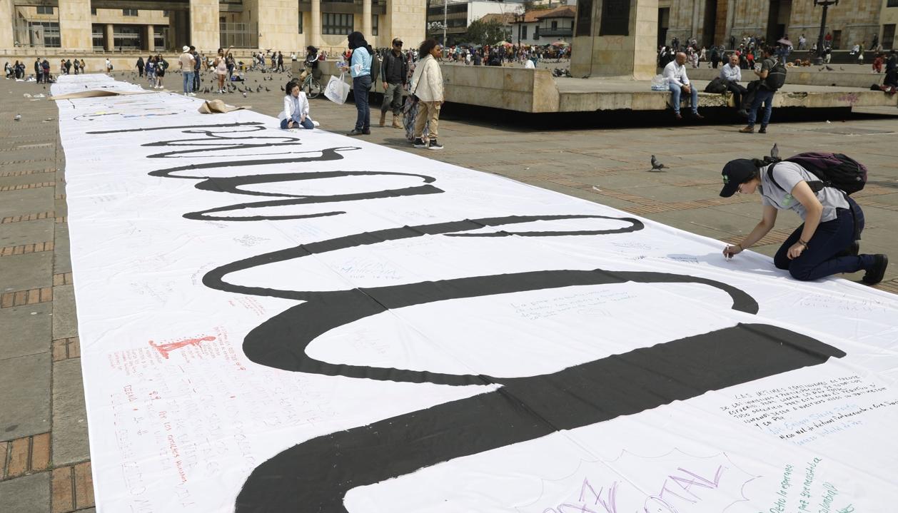 Imagen de referencia de personas que escribieron mensajes sobre una tela durante la conmemoración de los seis años de la firma del Acuerdo de Paz.