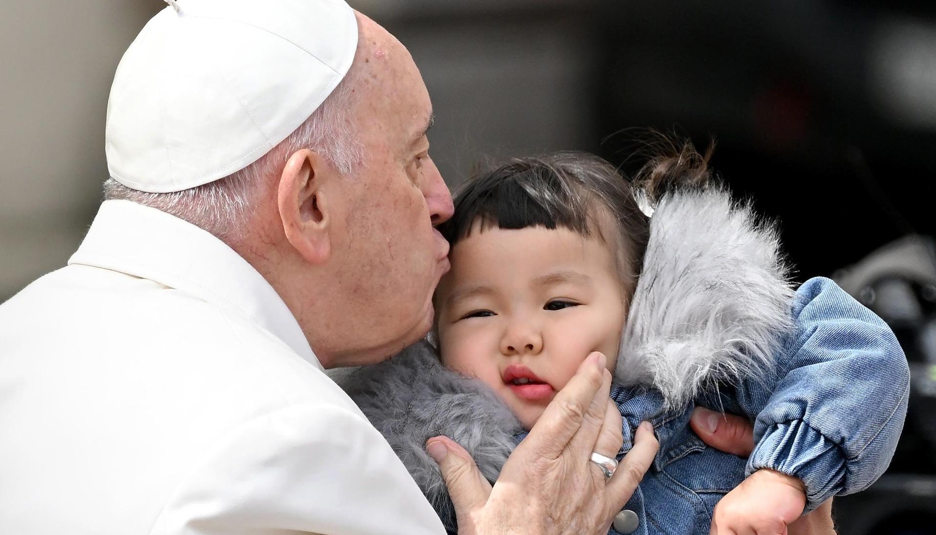 El papa Francisco besa a un niño este miércoles al final de su audiencia general semanal en la Plaza de San Pedro.