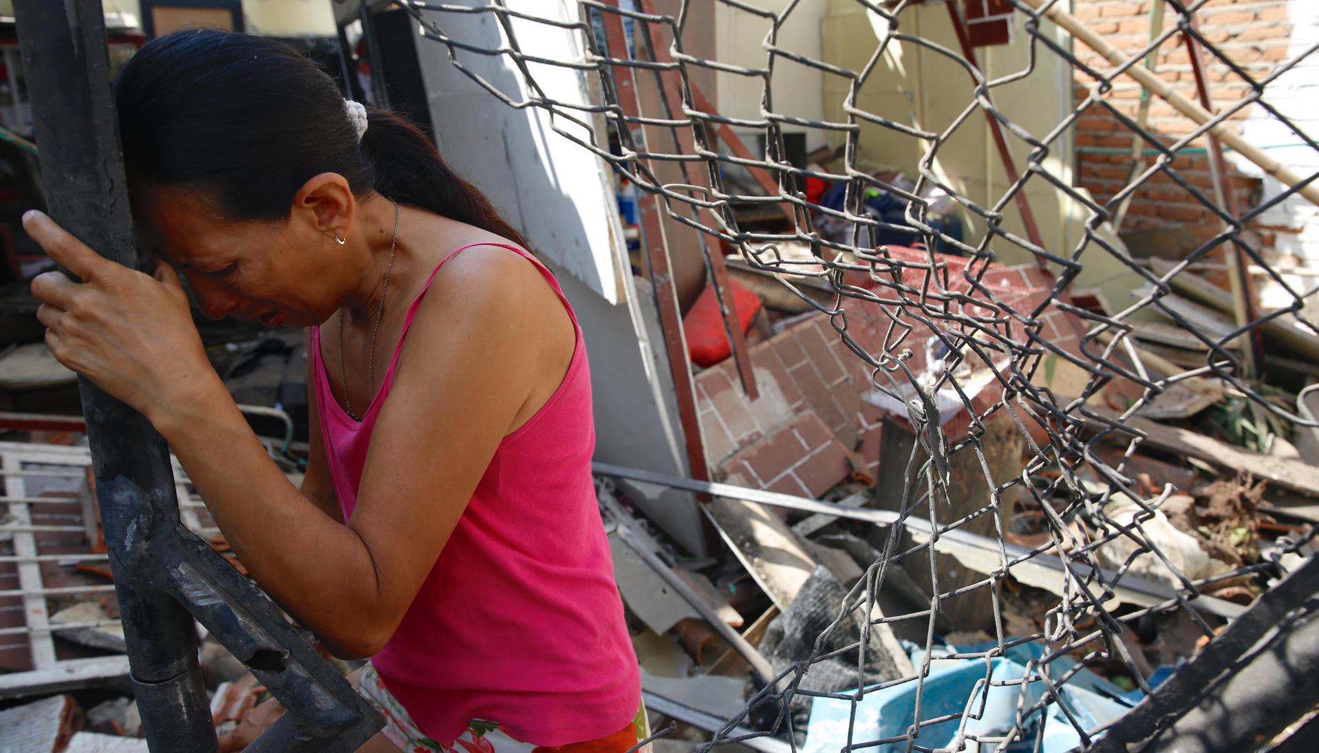 Mónica Grajales llora en la puerta de su vivienda destruida por un carro bomba ocurrido en Potrerito, zona rural de Jamundí