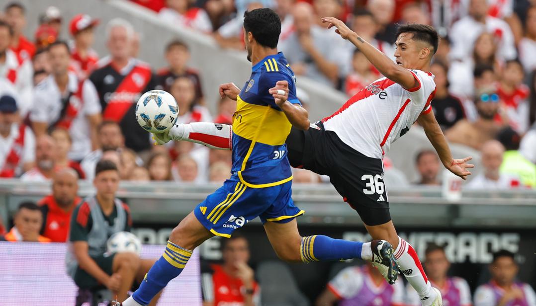 Pablo Solari, de River Plate, disputa el balón con Jorge Figal, de Boca.