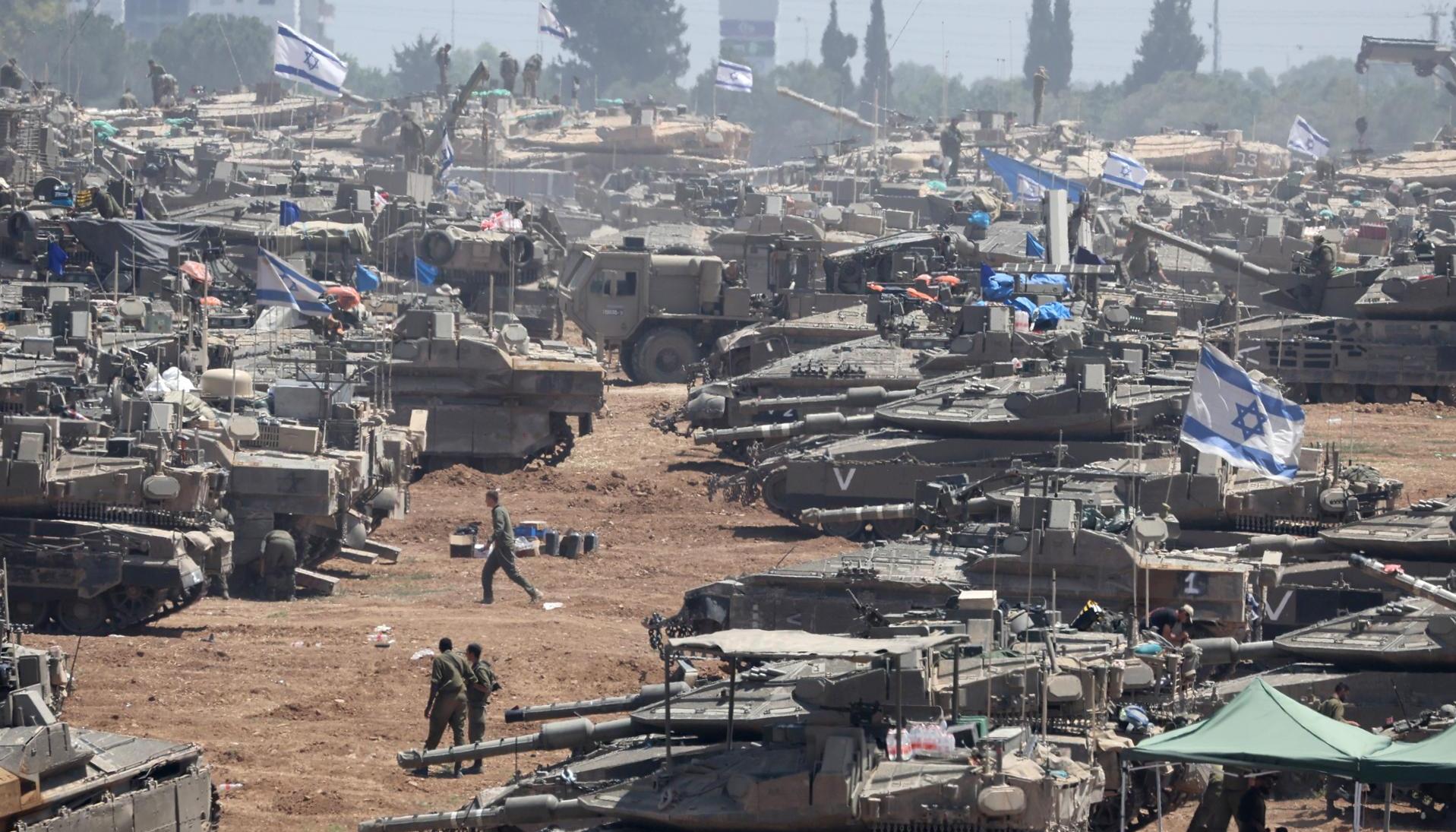 Soldados israelíes junto a sus vehículos militares se reúnen en Gaza.