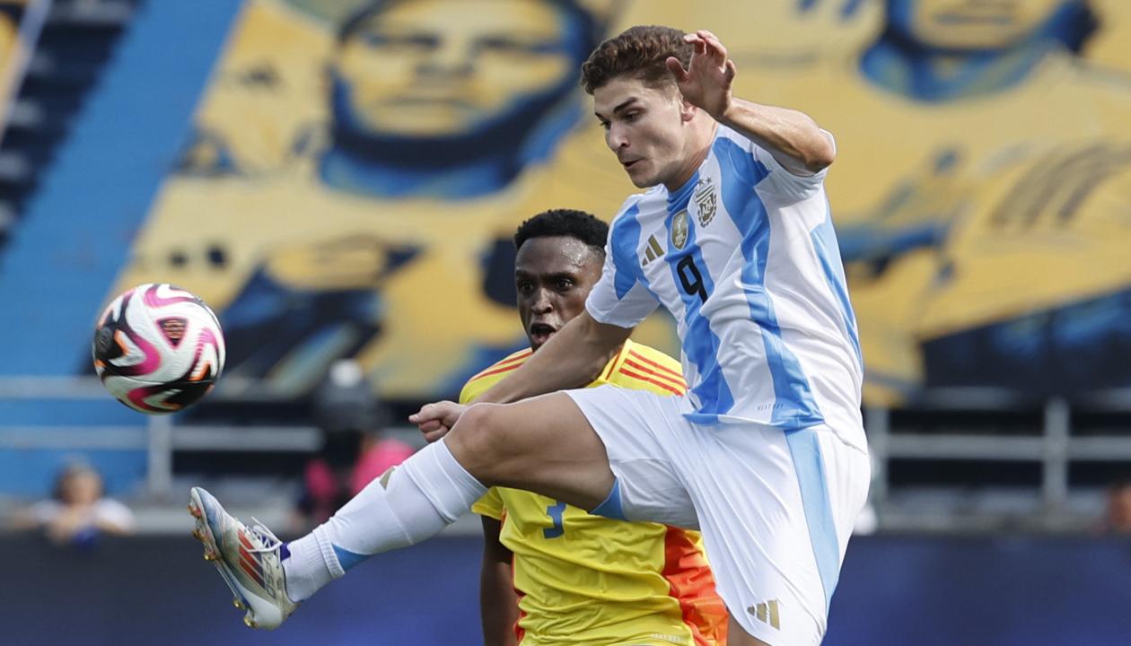 Julián Álvarez intenta dominar la pelota ante la marca de Jhon Lucumí. 