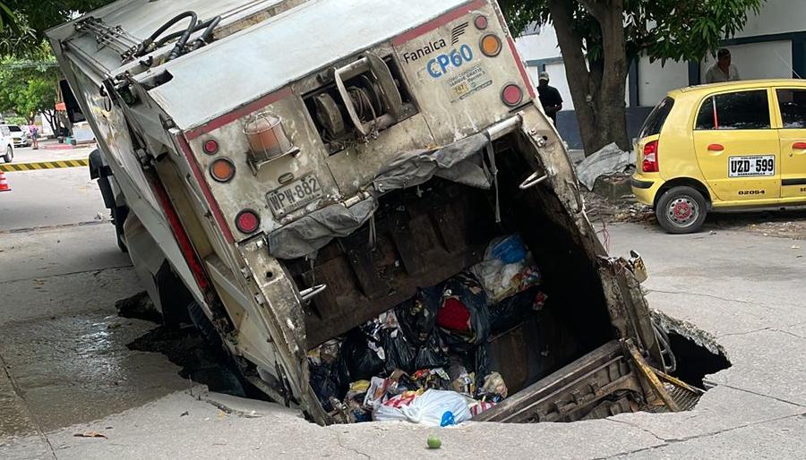 Camión de basura en gigante hueco que se abrió en el barrio Buenos Aires. 