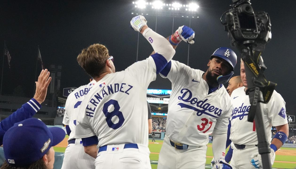 Kiké Hernández se saluda con Teoscar Hernández tras el jonrón de este último en el séptimo inning.