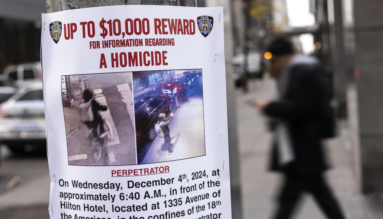 Cartel de "Se busca" en Nueva York cerca del lugar donde asesinaron a Brian Thompson.