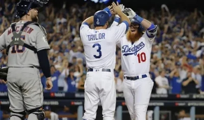Justin Turner, de Dodgers, celebra con Chris Taylor luego de batear un jonrón contra Astros.