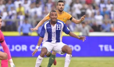 El jugador australiano Aziz Behich (atrás) disputa el balón con el hondureño Carlos Lanza (frente) 