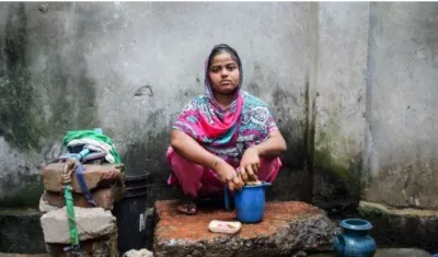 Rasheda, madre de dos niños, lava ropa en la parte trasera de su casa, cerca de una cloaca, en Chittagong (Bangladesh).