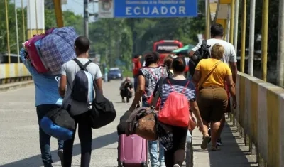 Fotografía fechada ayer domingo, 25 de agosto de 2019, que muestra a una familia venezolana mientras trata de cruzar el paso fronterizo de San Miguel (Ecuador).