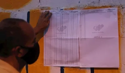 Un hombre identifica su lugar de votación hoy, en un centro de votación en Caracas (Venezuela). 