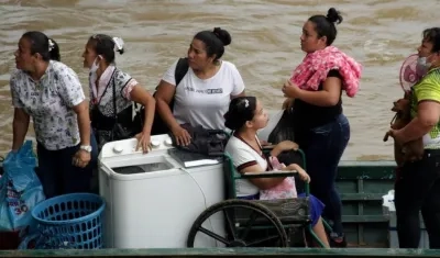 Migrantes venezolanos cruzan en botes hacia Colombia.