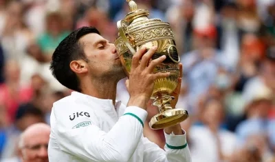 Novak Djokovic besa el trofeo de campeón de Wimbledon.