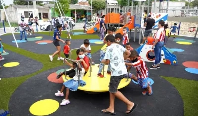Niños y adultos disfrutando en el parque.