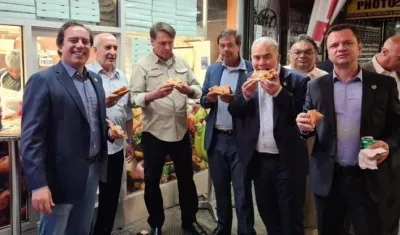 Jair Bolsonaro y miembros de su delegación comiendo pizza en una calle de NY.