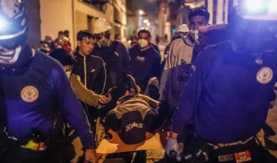 Un manifestante herido en enfrentamientos con la Policía recibe ayuda en el centro de Lima.