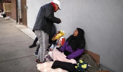 Inmigrantes indocumentados mexicanos comen en el suelo en una calle de la ciudad fronteriza de El Paso, Texas.