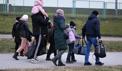 Personas que huyen de los conflictos entre Rusia y Ucrania llegan a la frontera polaco-ucraniana en Medyka, sureste de Polonia.