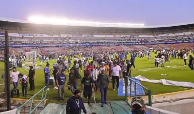 Hinchas abandonan la cancha del estadio Corregidora. 