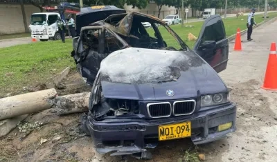 Automóvil BMW tras chocar y caerle encima el poste e incendiarse.