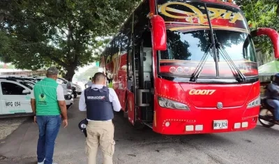 Funcionario de Migración Colombia inspeccionan un bus. 