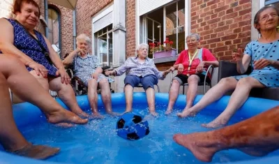Mujeres se refrescan con los pies metidos en una piscina de plástico en una residencia de ancianos en Chatelet, Bélgica, donde se registran temperaturas de hasta 40 grados. 