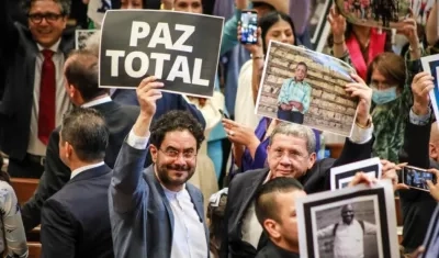 El senador Iván Cepeda, muestra un cartel sobre la paz.